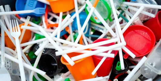 Plastic cutlery and straws piled up.